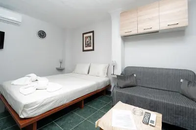 a hotel room with a bed and a couch at Panos Marina Apartment P1 in Porto Rafti