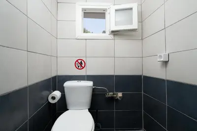 a bathroom with a toilet and a window at Panos Marina Apartment P1 in Porto Rafti