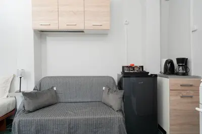 a living room with a chair and a refrigerator at Panos Marina Apartment P1 in Porto Rafti