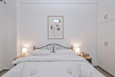 a white bedroom with a white bed with two lamps at Irida Stylish, Cozy, Fully Equipped Apt in Piraeus