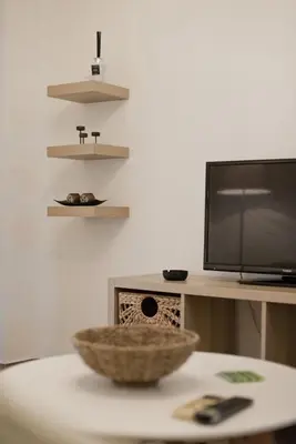 a living room with a table with a television and a bowl at Irida Stylish, Cozy, Fully Equipped Apt in Piraeus