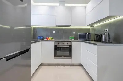 a kitchen with white cabinets and a microwave at Lemon Tree House Varkiza in Vari