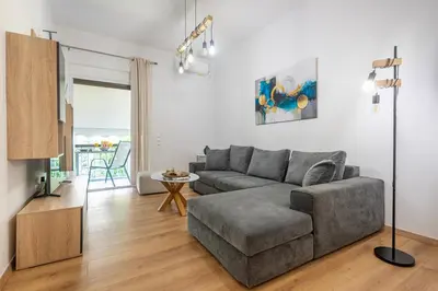 a living room with a gray couch and a table at Lemon Tree House Varkiza in Vari