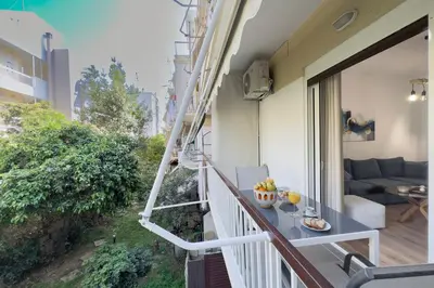 a room with a balcony with a table and a couch at Lemon Tree House Varkiza in Vari