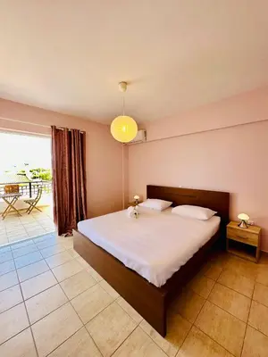 a bedroom with a large bed and a balcony at Airfenos - Athens Riviera in Anavissos