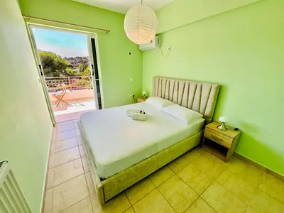 a bedroom with a bed with a view of a balcony at Airfenos - Athens Riviera in Anavissos