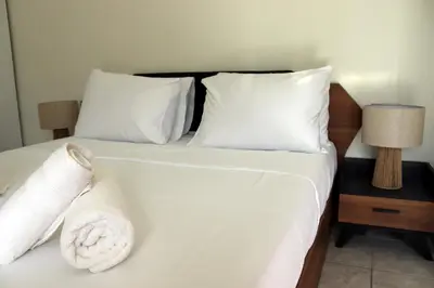 a bed with white sheets and pillows on it at Feel Breeze Athens in Athens