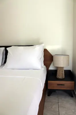 a bed with a nightstand with a lamp on it at Feel Breeze Athens in Athens