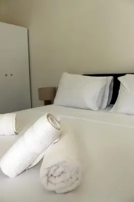 a rolled up towel on a bed in a hotel room at Feel Breeze Athens in Athens