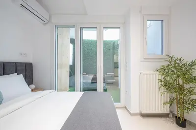 a bedroom with a bed and a large window at Seaside Corner Kastella Getaway in Piraeus