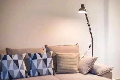 a lamp sitting on top of a couch with pillows at Seaside Corner Kastella Getaway in Piraeus