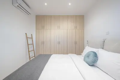 a bedroom with a white bed with a blue ball on it at Seaside Corner Kastella Getaway in Piraeus