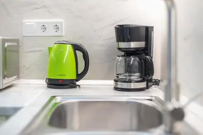 a green and black coffee maker sitting on a kitchen counter at Seaside Corner Kastella Getaway in Piraeus