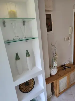 a white shelf with glass vases on it at Lefkothea's house in Athens