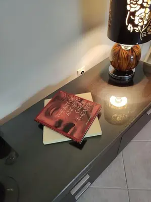 a book sitting on a table next to a lamp at Lefkothea's house in Athens