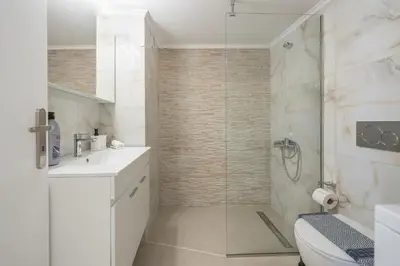 a bathroom with a shower and a toilet and a sink at Kastela's Harbor Retreat with Jacuzzi in Piraeus