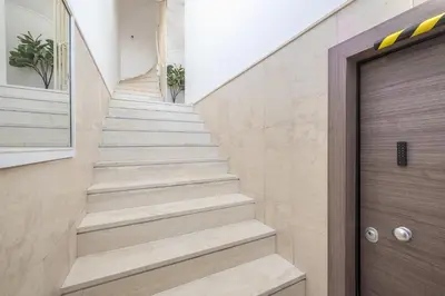 a staircase in a house with a wooden door at Kastela's Harbor Retreat with Jacuzzi in Piraeus