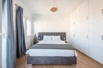 a bedroom with a large bed with white cabinets at Sea Breeze Suite with Jacuzzi in Piraeus