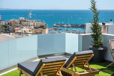 a balcony with two chairs and a view of the ocean at Sea Breeze Suite with Jacuzzi in Piraeus