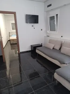 a living room with a couch and a television at CozyStation in Athens
