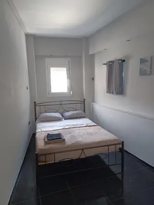 a bedroom with a bed in a white room at CozyStation in Athens