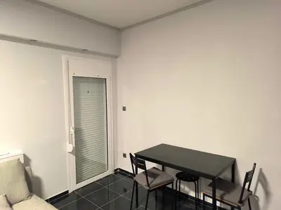 a dining room with a table and chairs and a couch at CozyStation in Athens