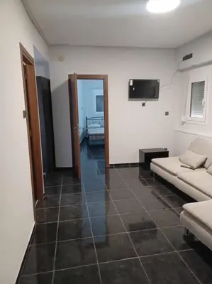 a living room with a couch and a television at CozyStation in Athens