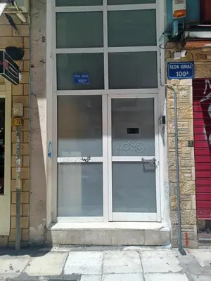 a glass door on a building with a street sign at CozyStation in Athens