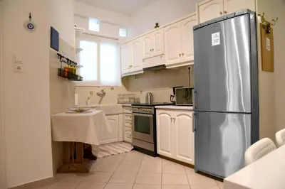 a kitchen with white cabinets and a stainless steel refrigerator at Elektras Akropolis Apartment in Athens