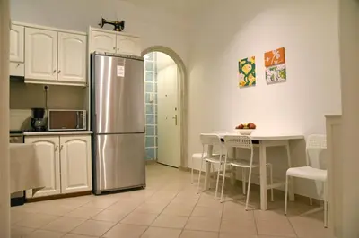 a kitchen with a stainless steel refrigerator and a table at Elektras Akropolis Apartment in Athens