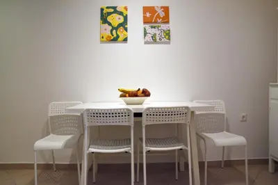 a white table with chairs and a bowl of fruit on it at Elektras Akropolis Apartment in Athens