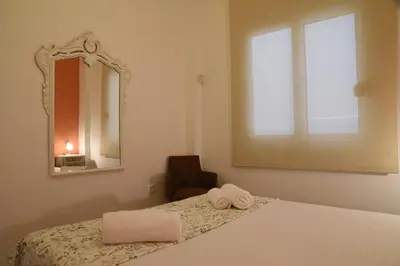 a bedroom with a bed with a mirror and a chair at Elektras Akropolis Apartment in Athens
