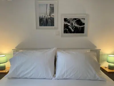 a bed with two white pillows and two pictures above it at EMERALD LAKE RESIDENCE in Athens