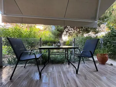 a table and chairs under an umbrella on a patio at EMERALD LAKE RESIDENCE in Athens