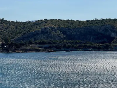 a large body of water with a mountain in the background at EMERALD LAKE RESIDENCE in Athens