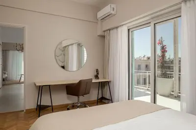 a bedroom with a bed and a desk and a mirror at Victoria Luxury Suite - Private Jacuzzi & Terrace in Athens
