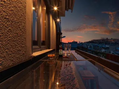 a balcony with a bottle of wine and a view of a city at Acropolis Music Studio Loft in Athens