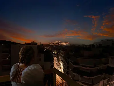 a woman standing on a balcony looking at the city at Acropolis Music Studio Loft in Athens