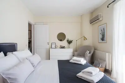 a bedroom with a white bed with towels on it at Faliro Riviera Seaview flat in Athens