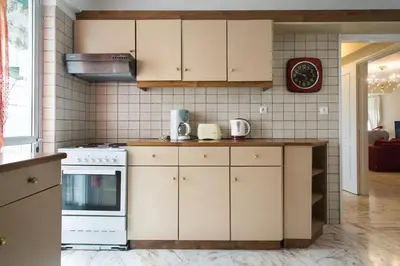 a kitchen with white cabinets and a stove at Faliro Riviera Seaview flat in Athens