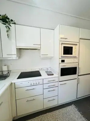 a white kitchen with white cabinets and appliances at Comfortable and Bright 2bdr flat in Athens