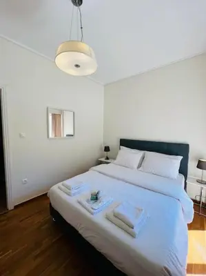 a bedroom with a large white bed with towels on it at Comfortable and Bright 2bdr flat in Athens