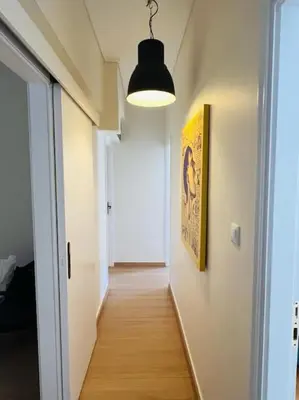 a hallway with a light fixture and a hallway with a door at Comfortable and Bright 2bdr flat in Athens