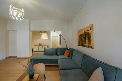 a living room with a blue couch and a table at Comfortable and Bright 2bdr flat in Athens