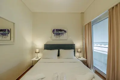 a bedroom with a large bed and a large window at Comfortable and Bright 2bdr flat in Athens