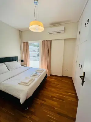 a bedroom with a bed and a large window at Comfortable and Bright 2bdr flat in Athens
