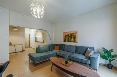 a living room with a blue couch and a table at Comfortable and Bright 2bdr flat in Athens