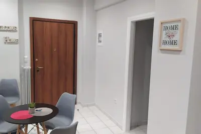 a room with a table and chairs and a wooden door at Dream apartment in Kallithea in Athens