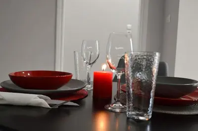 a table with a candle and plates and glasses at Dream apartment in Kallithea in Athens