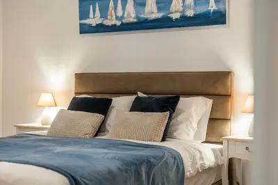 a bedroom with a bed with pillows and a painting at Hidden Treasure of Koukaki in Athens